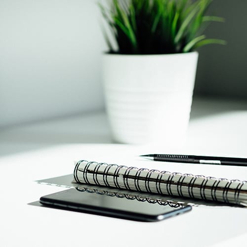 Tax advice image - Phone and book sitting on desk
