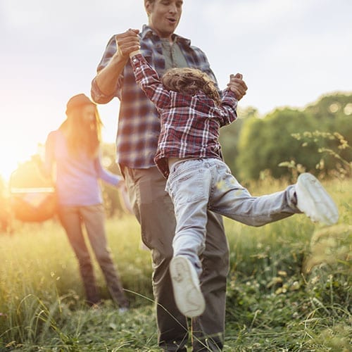 Trust and estates image - father swinging his child around in the grass.jpg