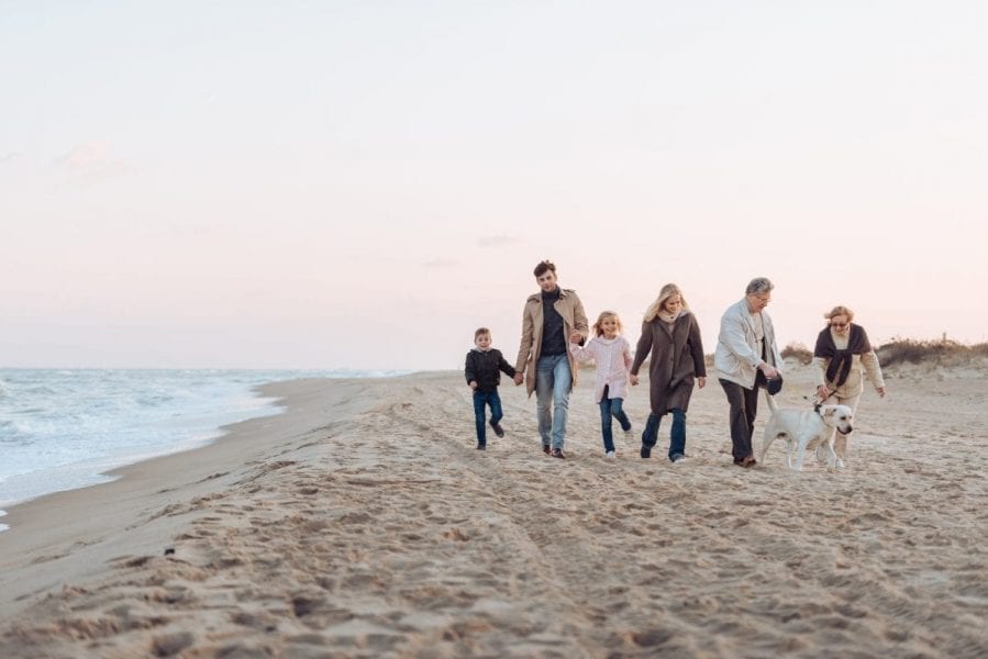 family walking with dog at seaside