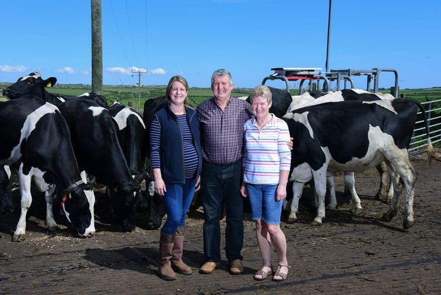 family pictured in front of cows and farm land