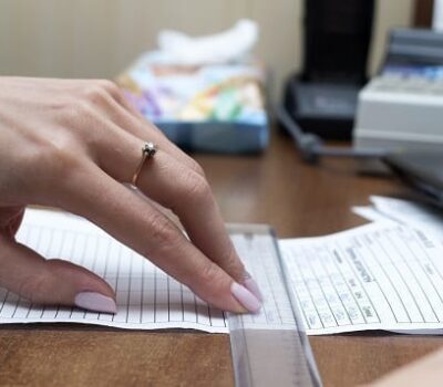 Woman Using Ruler On Paper Form Document