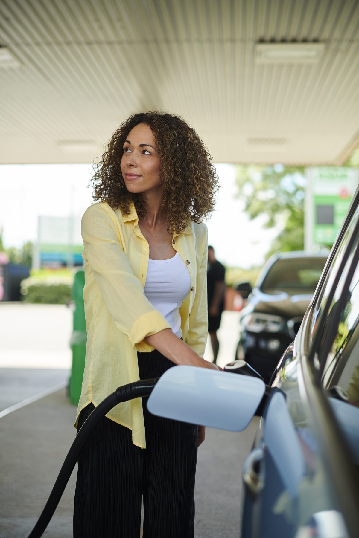 Woman filling up car at petrol station