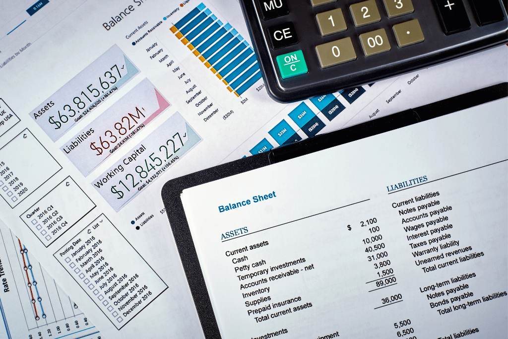 a balance sheet, some financial forecasts and a calculator on a desk