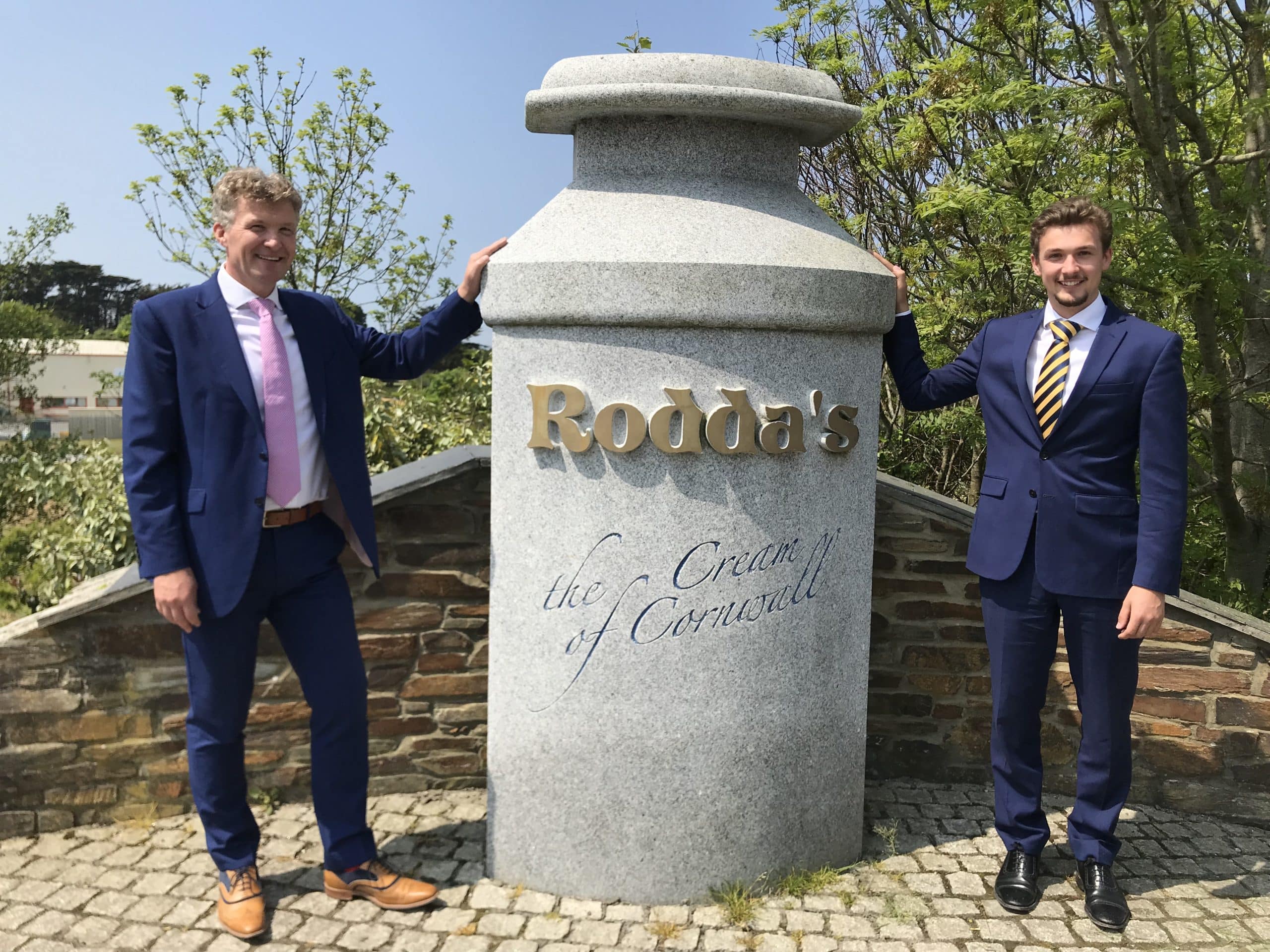 Nick and Alex Rodda stood either side of a giant concrete milk can that has the company logo with "the Cream of Cornwall" engraved underneath.